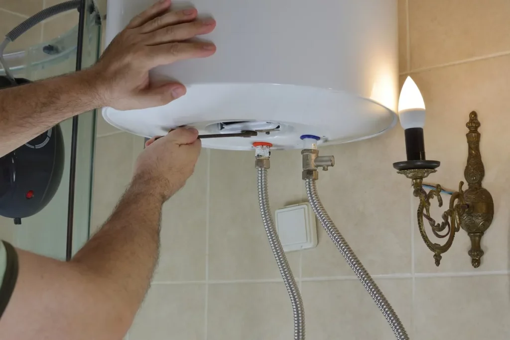 A person using a wrench to repair a boiler in a bathroom, illustrating common boiler installation myths.
